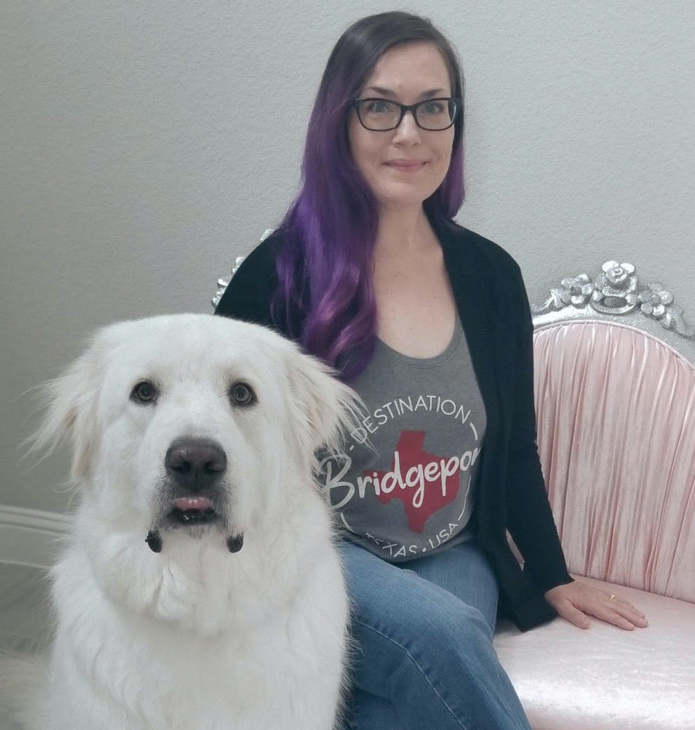 考特尼坐在粉红色的沙发上,旁边有一个毛茸茸的大白