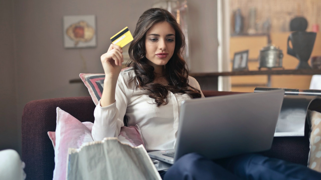 拿着信用卡看电脑的女人