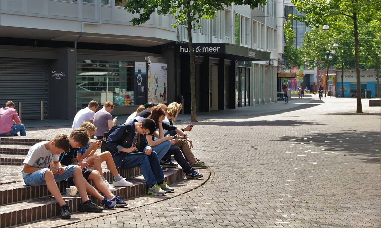 一群青少年坐在街上都在看他们的手机